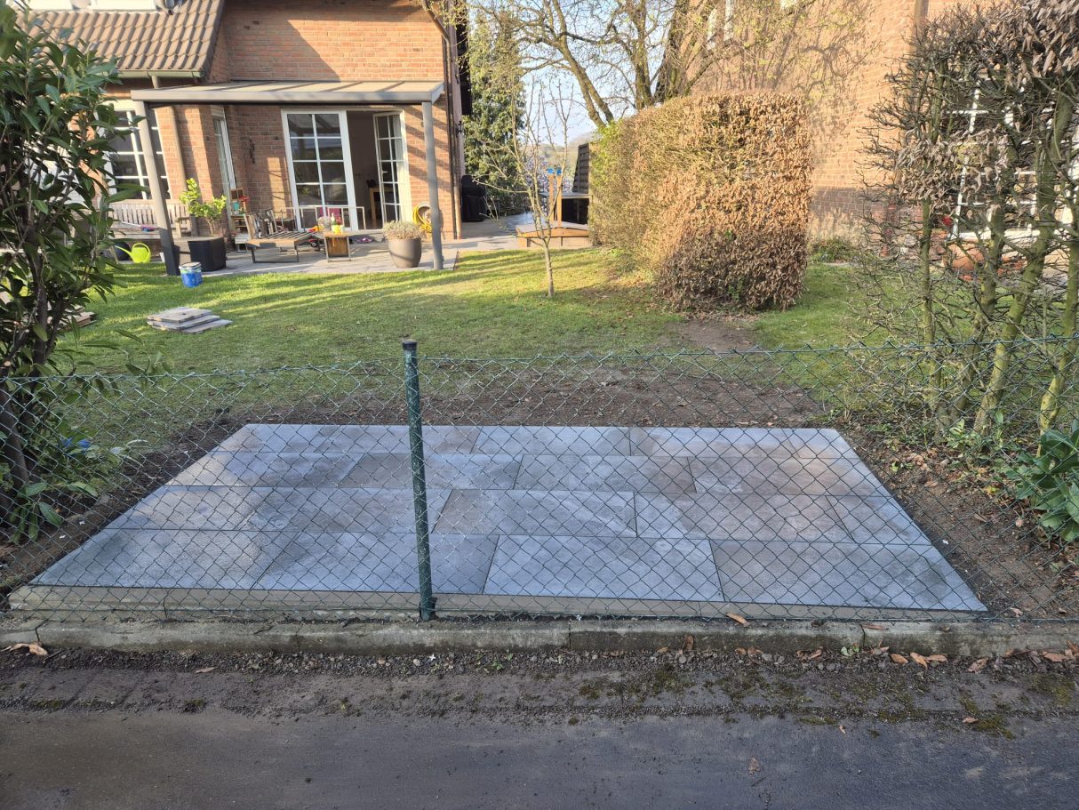 Neue ebene Terrasse nach Terrassenbau und Pflasterarbeiten in Langenfeld – hochwertige graue Pflastersteine mit Blick auf Haus und Garten