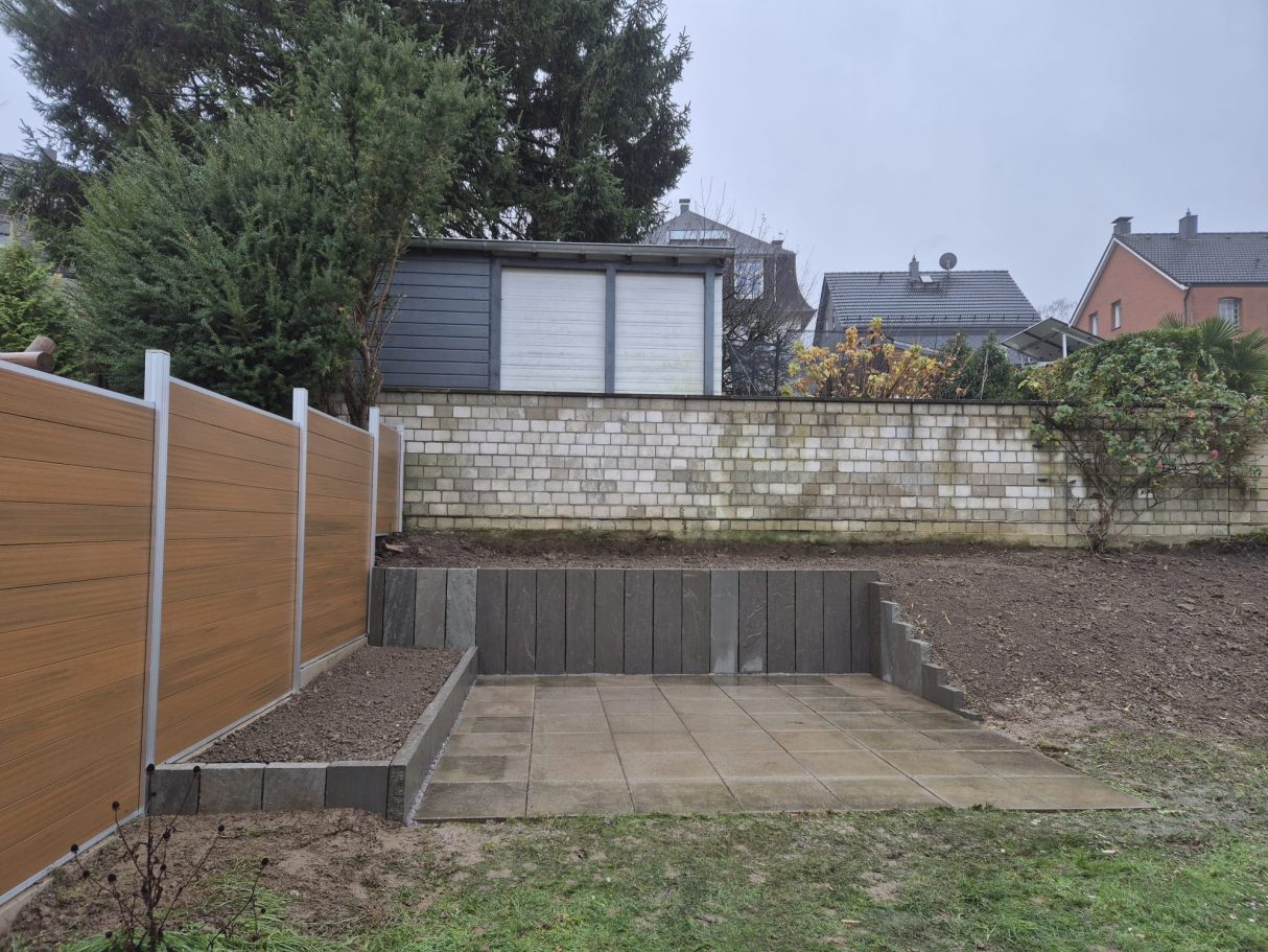 Nachher: Moderne, ebene Terrasse mit Pflastersteinen und Stützmauer nach Terrassenbau und Pflasterarbeiten in Wuppertal Elberfeld durch Syla