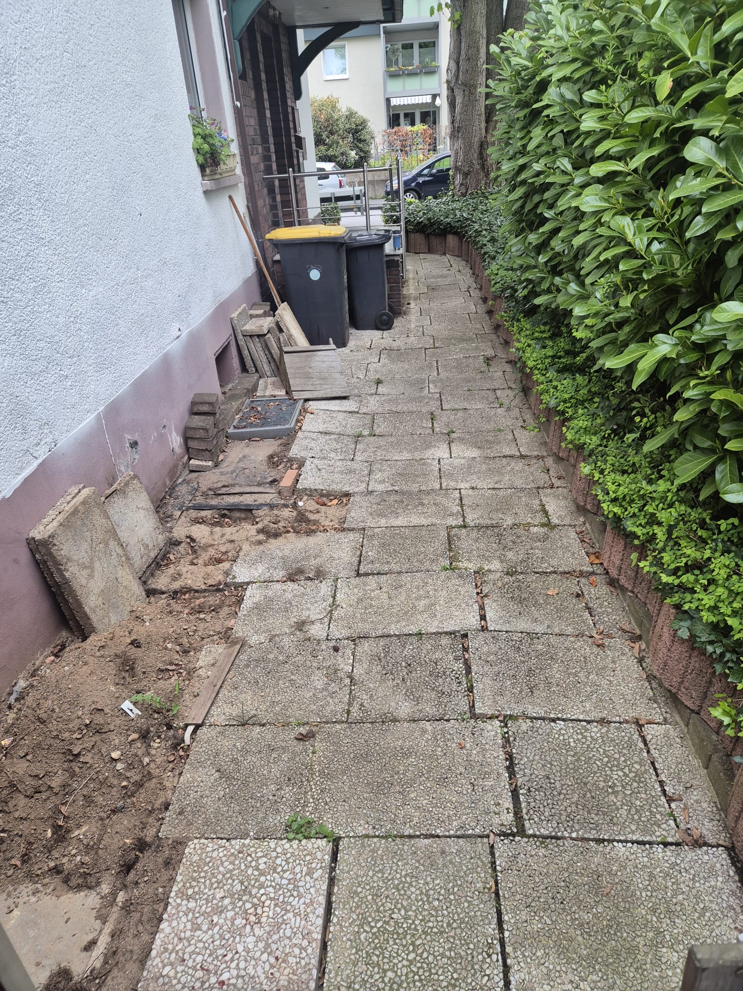 Vorher – Unebener Eingangsbereich vor Pflasterarbeiten in Mettmann Vorher:Unebener und verwitterter Eingangsbereich in Mettmann vor Pflasterarbeiten und dem Verlegen neuer Pflastersteine durch Syla Gartenbau