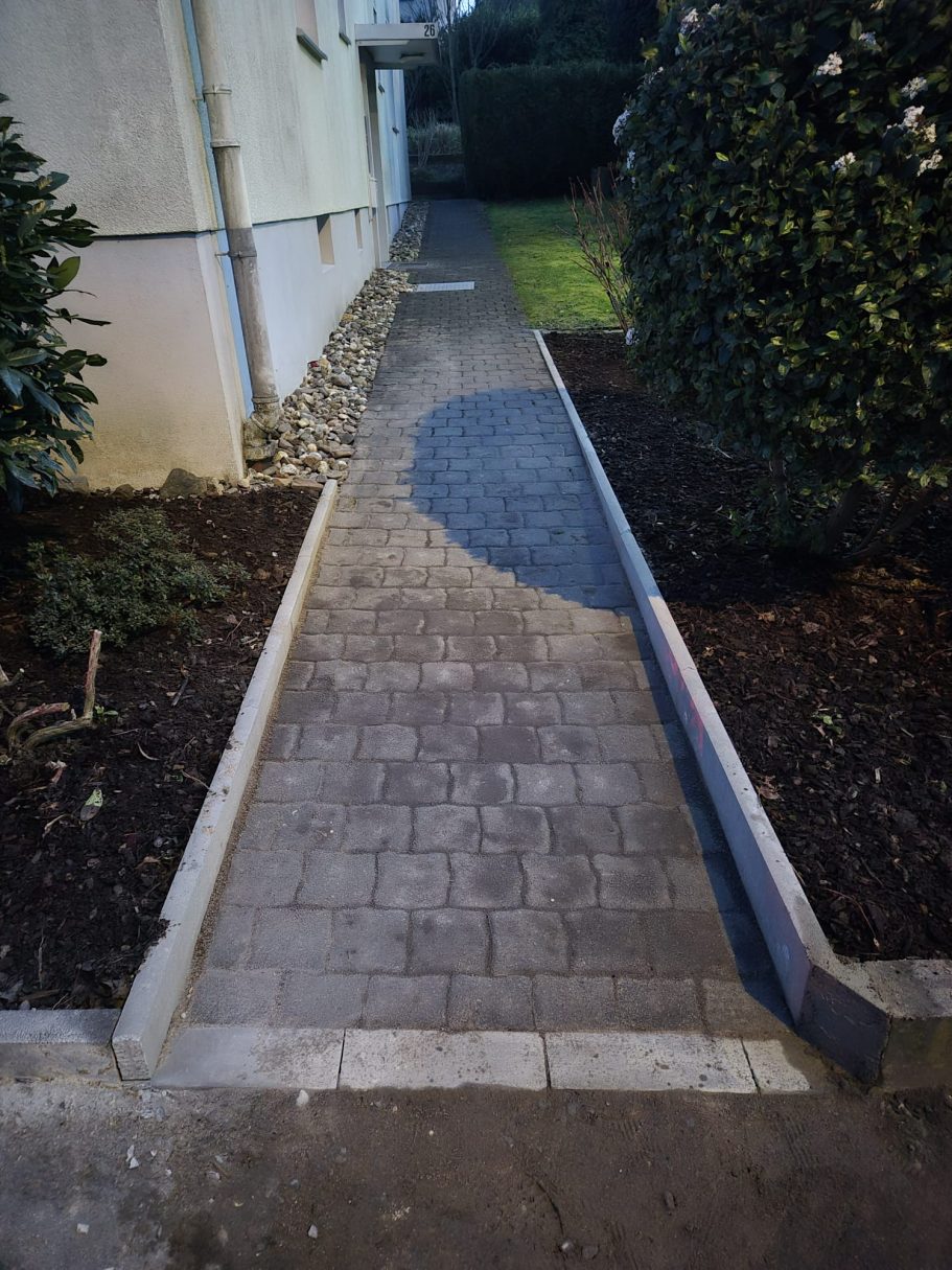 Nachher: Moderner, sauber und präzise verlegter Gartenweg nach Pflasterarbeiten in Hilden durch Syla Gartenbau